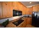 Modern kitchen features stainless steel appliances, granite countertops, and custom wood cabinets at 19880 W Desert Views Dr, Casa Grande, AZ 85122