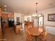 Eat-in kitchen features natural wood cabinetry, stone countertops, and a breakfast table at 19880 W Desert Views Dr, Casa Grande, AZ 85122