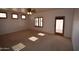 Living room featuring neutral carpet, windows, and ceiling fan at 19880 W Desert Views Dr, Casa Grande, AZ 85122