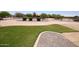 Well maintained front yard with healthy green grass and decorative desert landscaping at 19880 W Desert Views Dr, Casa Grande, AZ 85122