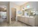 Large primary bathroom featuring a double vanity, tile floors, and a doorway to the bedroom at 20039 N Hearthstone Dr, Surprise, AZ 85374