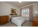 Comfortable bedroom with a large window, soft carpet, and traditional wood furniture at 20039 N Hearthstone Dr, Surprise, AZ 85374