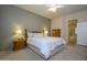 Relaxing primary bedroom with soft carpet, lamps, and an open doorway leading to the attached primary bathroom at 20039 N Hearthstone Dr, Surprise, AZ 85374