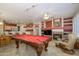 Open game room with pool table, fireplace, kitchen access, and comfortable seating area at 20039 N Hearthstone Dr, Surprise, AZ 85374