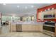 Bright kitchen with stainless steel appliances, light wood cabinets, and an adjacent living area for easy entertaining at 20039 N Hearthstone Dr, Surprise, AZ 85374