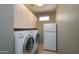 Convenient laundry room with updated washer, dryer, extra storage, and bonus refrigerator at 20039 N Hearthstone Dr, Surprise, AZ 85374