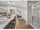 Bright bathroom featuring wood-style floors, white vanities with double sinks and walk-in glass shower at 20458 W Briarwood Dr, Buckeye, AZ 85396