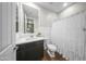 A modern bathroom with a sleek vanity, toilet, and shower featuring a decorative white curtain at 20458 W Briarwood Dr, Buckeye, AZ 85396