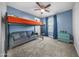 This cozy bedroom features a lofted bed, soft gray sofa, blue accent wall and natural light from a window at 20458 W Briarwood Dr, Buckeye, AZ 85396