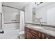 Bathroom with white tiled tub, toilet and wood vanity with granite countertop at 2119 E Daley Ln, Phoenix, AZ 85024