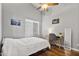 Bedroom featuring wood floors, white bedding, desk and ceiling fan at 2119 E Daley Ln, Phoenix, AZ 85024