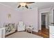 Bedroom with a crib, hardwood floors, white walls, a chair, and a ceiling fan at 2119 E Daley Ln, Phoenix, AZ 85024