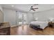 Bright bedroom with wood floors, ceiling fan, king bed, and French doors to a pool area at 2119 E Daley Ln, Phoenix, AZ 85024