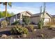 Inviting single-story home showcasing desert landscaping, including cacti and shrubs, providing a unique curb appeal at 2119 E Daley Ln, Phoenix, AZ 85024