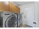 Laundry room featuring front loading washer and dryer and cabinetry at 2119 E Daley Ln, Phoenix, AZ 85024