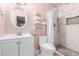 Pretty pink bathroom featuring white vanity, toilet, and white-tiled shower, with pink walls at 2132 W Chambers St, Phoenix, AZ 85041