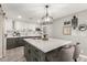 Kitchen with island, white cabinets, gray lowers, stainless appliances, tile backsplash and hanging light fixture at 2132 W Chambers St, Phoenix, AZ 85041