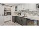 Kitchen area featuring white cabinetry with gray lower cabinets, backsplash, and a beverage cooler at 2132 W Chambers St, Phoenix, AZ 85041