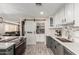 Well-lit kitchen with gray and white cabinetry, stainless appliances, and sliding barn door to pantry at 2132 W Chambers St, Phoenix, AZ 85041