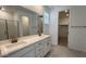 Bright bathroom with double vanity sinks, large mirror, and walk-in shower at 25138 W Wayland Dr, Buckeye, AZ 85326