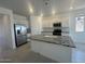Modern kitchen with stainless steel refrigerator, granite countertops, and white cabinets at 25138 W Wayland Dr, Buckeye, AZ 85326
