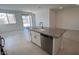 White kitchen island with granite countertop, sink, and stainless steel dishwasher at 25138 W Wayland Dr, Buckeye, AZ 85326
