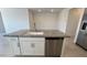 White kitchen island with granite countertop, sink, and stainless steel dishwasher at 25138 W Wayland Dr, Buckeye, AZ 85326