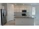 Kitchen showcasing stainless appliances, granite counters, and an island with a sink at 25138 W Wayland Dr, Buckeye, AZ 85326
