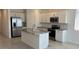 Bright kitchen features stainless appliances, granite counters, and a large island with a sink at 25138 W Wayland Dr, Buckeye, AZ 85326