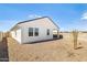 Exterior shot of backyard with rock cover, privacy wall, covered patio, and clear blue sky at 25455 N 183Rd Dr, Wittmann, AZ 85361