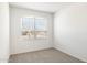 Inviting bedroom featuring a large window, neutral carpeting, and light, neutral walls at 25455 N 183Rd Dr, Wittmann, AZ 85361
