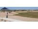 An expansive community park with grassy areas, walking paths, and shaded pavilions encourages outdoor activities and relaxation at 25455 N 183Rd Dr, Wittmann, AZ 85361