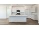 Modern kitchen features an island, sleek white cabinets, and stainless steel appliances at 25455 N 183Rd Dr, Wittmann, AZ 85361