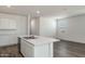 Bright kitchen boasts an island, white cabinets, stainless steel appliances, and wood flooring at 25455 N 183Rd Dr, Wittmann, AZ 85361