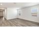 Spacious living room with durable, wood-look flooring, bright natural light, and an open-concept design at 25455 N 183Rd Dr, Wittmann, AZ 85361