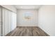 Bright living room featuring sleek wood-look flooring, slider door, and a window for ample natural light at 25455 N 183Rd Dr, Wittmann, AZ 85361
