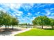 Picturesque pond surrounded by trees, grassy areas, and a walking path under a beautiful sky at 25455 N 183Rd Dr, Wittmann, AZ 85361