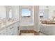 Stylish bathroom with a tub, vanity, large window, and neutral color palette at 25720 W White Feather Ln, Wittmann, AZ 85361