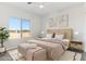 Cozy bedroom featuring a plush bed, large window, and minimalist decor at 25720 W White Feather Ln, Wittmann, AZ 85361