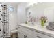 Bright bathroom features a tub and shower, white vanity with solid surface top, and decorative shower curtain at 25876 W White Feather Ln, Wittmann, AZ 85361