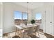 Inviting dining area featuring a modern table set, large windows, and stylish flooring at 25876 W White Feather Ln, Wittmann, AZ 85361