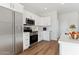 Bright, functional kitchen with stainless steel appliances, white cabinets, and plenty of counter space at 25876 W White Feather Ln, Wittmann, AZ 85361