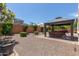 Well-maintained backyard features a covered patio, gravel ground cover, and mature landscaping at 25995 W Sierra Pinta Dr, Buckeye, AZ 85396