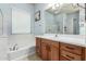 Bright bathroom featuring a tub, and wood cabinets beneath a white countertop at 25995 W Sierra Pinta Dr, Buckeye, AZ 85396
