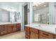 Bathroom featuring double sinks, wood cabinets, and a framed mirror, with tile floors at 25995 W Sierra Pinta Dr, Buckeye, AZ 85396