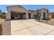 Home with a large three-car garage featuring storage and desert landscaping at 25995 W Sierra Pinta Dr, Buckeye, AZ 85396