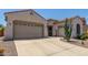 This home has a large driveway leading to a three-car garage, and desert landscaping at 25995 W Sierra Pinta Dr, Buckeye, AZ 85396