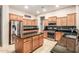 Modern kitchen with a central island, stainless steel appliances, and sleek granite countertops, perfect for cooking at 25995 W Sierra Pinta Dr, Buckeye, AZ 85396