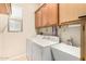 Laundry area with washer, dryer, utility sink, storage cabinets, and window at 25995 W Sierra Pinta Dr, Buckeye, AZ 85396