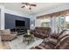 Enjoy this stylish living room with a large TV, comfortable seating, and a ceiling fan for year-round comfort at 25995 W Sierra Pinta Dr, Buckeye, AZ 85396